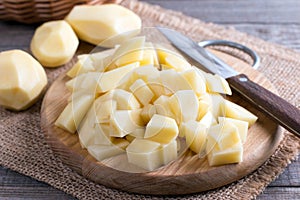 Raw potatoes, chopped cubes on a wooden board