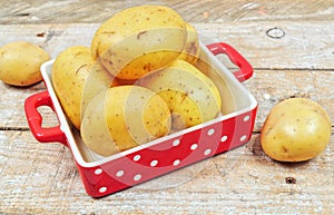 Raw potatoes in red tray