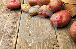 Raw potatoes on rustic background