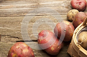 Raw potatoes on rustic background