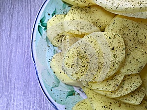 raw potatoes sprinkled with seasonings, cut into round pieces for boiling and baking