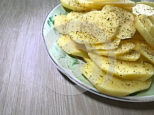 raw potatoes sprinkled with seasonings, cut into round pieces for boiling and baking