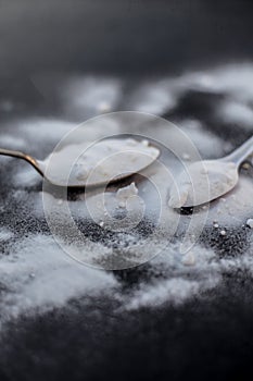 Raw powdered baking soda in a antique spoon on wooden surface