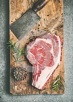 Raw prime beef meat dry-aged steak rib-eye and chopping knife