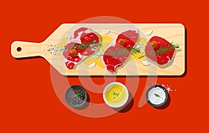 Raw prime beef steaks, rib eye, strip loin, tenderloin and seasoning on wooden cutting board