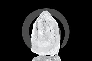 Raw pure quartz or berg crystal mineral stone in front of black background