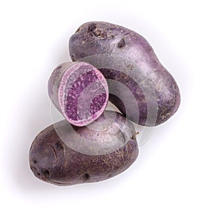 Raw purple potatoes isolated on white background. Top view, close-up