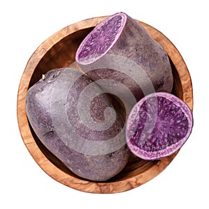 Raw purple potatoes in wooden bowl isolated on white background. Top view