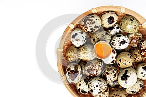 Raw quail eggs in basket on white background with space for tex, top view.