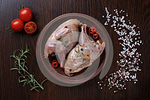 Raw quails ready for cooking on ceramic plate with spices