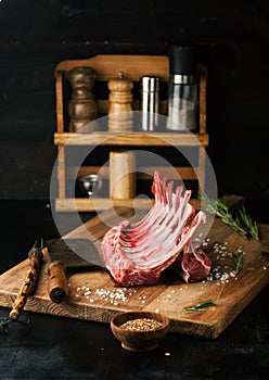 Raw rack of lamb with spices on a cutting board