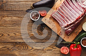 Raw rack of lamb on wooden board