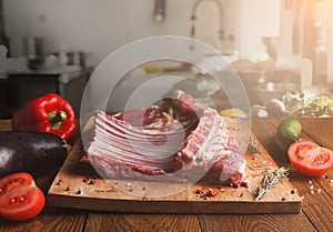 Raw rack of lamb on wooden board