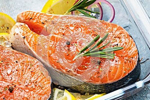 Raw red fish steak with various spices in a glass pallet