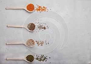Raw red lentils, yellow peas, mung bean and wheat in wooden spoons on a white background. Copy spaes