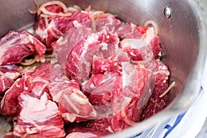 Raw red meat for barbecue in a plate. Pork cut into slices with onions