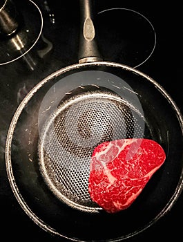 Raw red meat in a nonstick pan