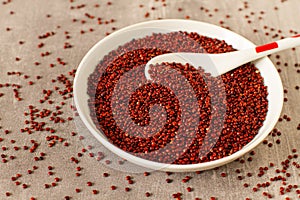 Raw red ouinoa in an white bowl on a table