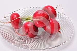 Raw red radishes on glass plate