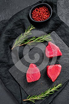 Raw red tuna steak. Black background. Top view