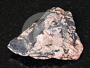 raw Rhodonite stone on black