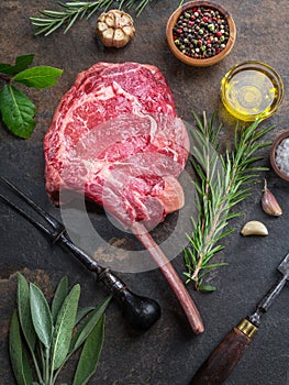 Raw Rib eye steak or beef steak on the graphite board with herbs and spices