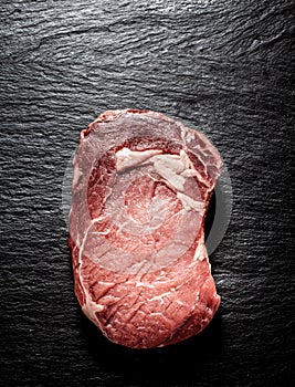 Raw Rib Eye Steak on Dark Grey Textured Surface