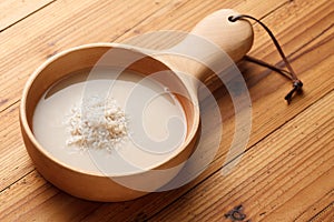 Raw rice and rice water are in wooden dishes.