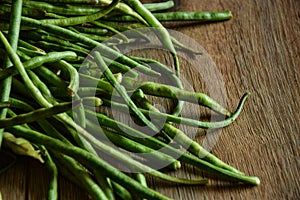 Raw ripe green asparagus bean wooden table indoors