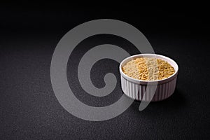 Raw risoni pasta made from durum wheat on a dark concrete background