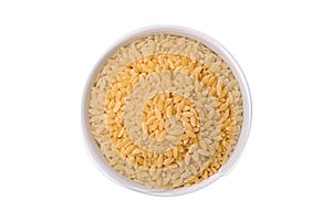 Raw risoni pasta made from durum wheat on a dark concrete background