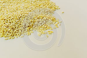 Raw risoni pasta is scattered on the table on a light background. The concept of traditional Italian cuisine.