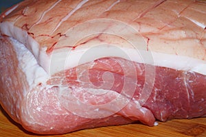 Raw roast pork with a crust on wooden background