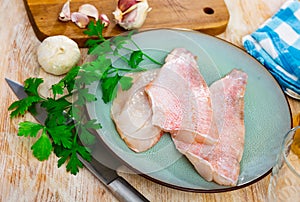 Raw rockfish fillet with condiments, cooking ingredients