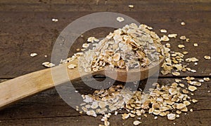 Raw rolled oats in wooden spoon