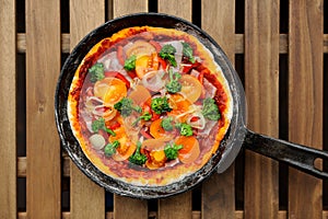 Raw round pizza with yellow cherry tomatoes, onion, garlic and b