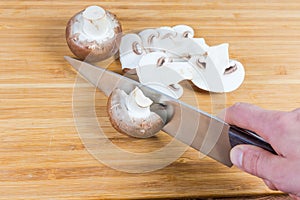 Raw royal champignon mushrooms during slicing on cutting board