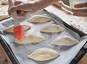 Raw pirozhki with cabbage in the cooking process.