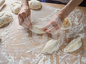Raw pirozhki with cabbage in the cooking process.