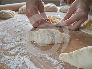 Raw pirozhki with cabbage in the cooking process.