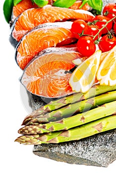 Raw salmon cuts with vegetables on rock