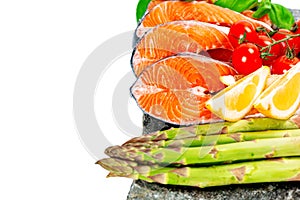 Raw salmon cuts with vegetables on rock