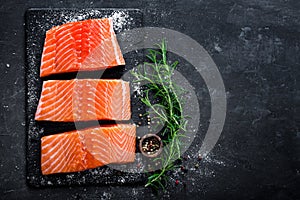 Raw salmon filet on dark slate background, wild atlantic fish, space for text