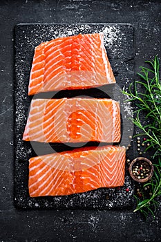 Raw salmon filet on dark slate background, wild atlantic fish, space for text