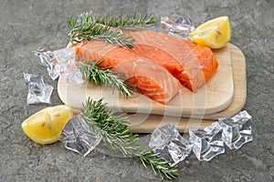 Raw salmon fillet with fresh rosemary herb, lemon and ice