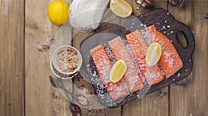 Raw salmon fillet with pepper sweetbread and salt on baking paper rustic theme with copy-space. Flat lay