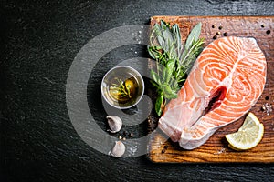 Raw salmon with herbs and spices, rustic background