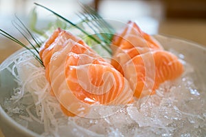 Raw salmon slice or salmon sashimi in Japanese style fresh serve on ice in bowl