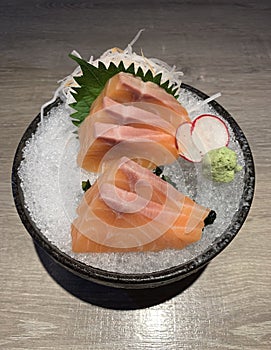 Raw salmon slice or salmon sashimi in Japanese style fresh serve on ice with fresh wasabi