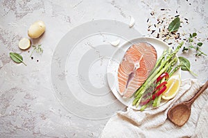 Raw salmon steak with fresh vegetables for garnish